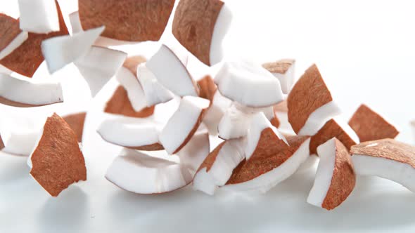 Super Slow Motion Shot of Fresh Coconut Pieces Falling on White Background at 1000Fps alt