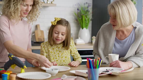 Video of three generations of women making handmade Easter decorations alt