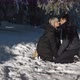 Beautiful Couple Enjoying a Winter Day in the Forest sitting in Snow Holding Hands and Kissing - VideoHive Item for Sale