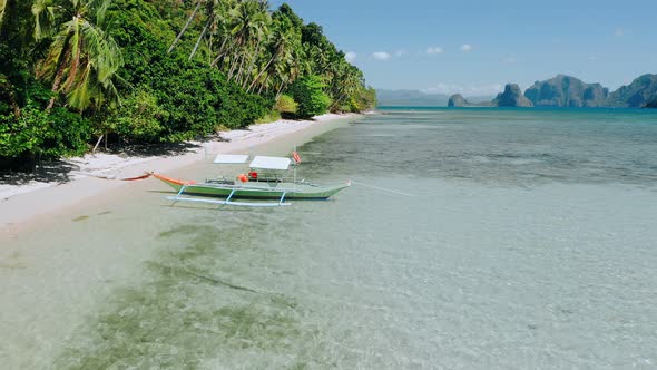 Aerial Drone Flying Along Exotic Cost Over Banca Boat in Shallow Lagoon Water at the Low Tide alt