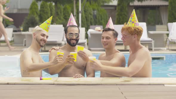 Positive Friends in Party Hats Congratulating Middle Eastern Groom on Stag-party. Portrait of alt