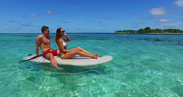 Young couple on romantic honeymoon enjoy life on beach on paradise white sand 4K background alt