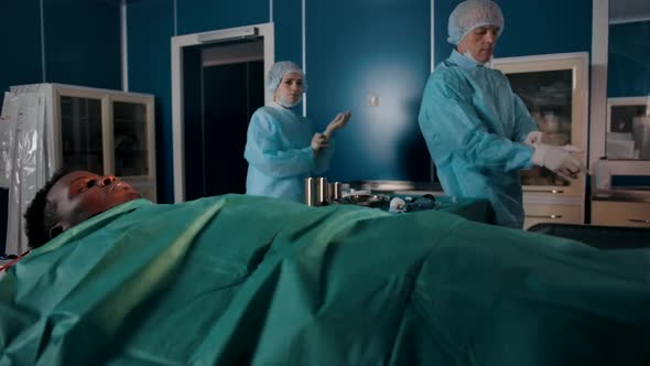 Two Experienced Surgeons in Special Robes Come to the Operating Room alt