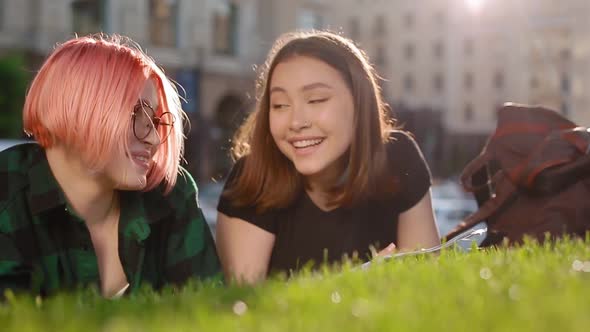Two Female Student on the Grass with a Book