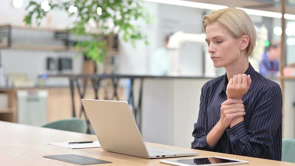 Stressed Woman Working on Laptop Having Wrist Pain in Office  alt