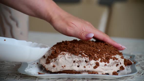 Woman Covers Cake with Biscuit Crumbs