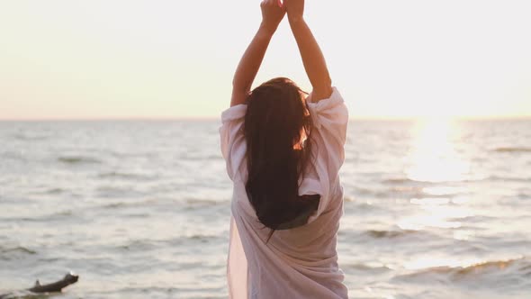 Beautiful Girl Dancing on the Beach in a White Shirt. Free Girl with Long Hair in a White Shirt alt