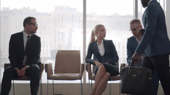 Diverse Group of Job Applicants in Formal Wear Sitting in Line and Waiting for Interview