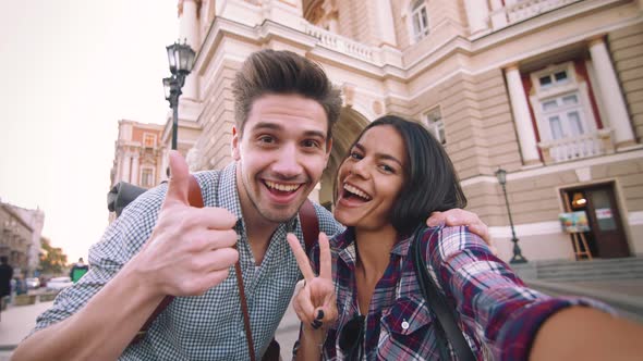 POV of the Young Mixed Race Tourist Couple Taking Selfie in Old City Center and Having Some Fun alt