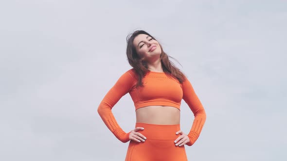 Muscular woman goes in for sports outdoors. He tilts his head and smiles. Healthy adult woman in spo alt