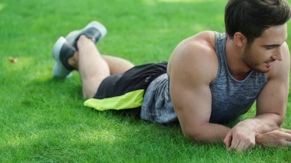 Smiling Couple Talking Together and Lying on Grass in Park. Happy Couple alt