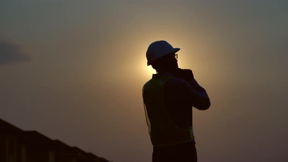 silhouette Civil engineer inspection building and calling on site  