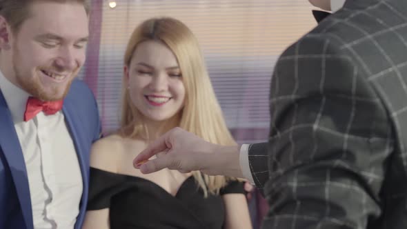 Professional Magician Shows a Trick To a Beautiful Couple. Guy and the Girl Are Surprised and Very alt