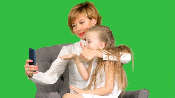 Happy woman and child taking a selfie on a Green Screen, Chroma Key