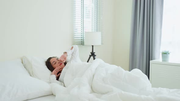 Latino beautiful sick girl in pajamas getting up from sleep in bedroom. alt