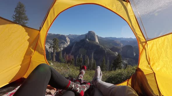 Two Pairs of Stretched Legs on the Background of Sierra Nevade Ridges and Half Dome Rock. Yosemite alt