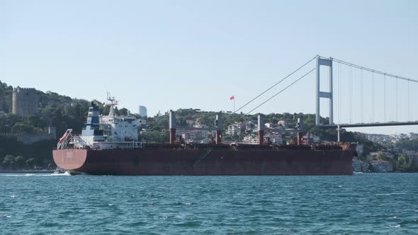 A red tanker ship was passing under The Fatih Sultan Mehmet Bridge 
