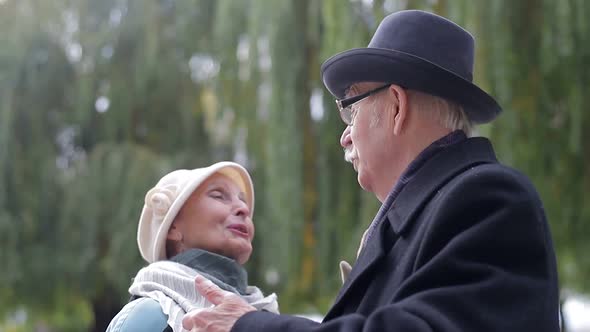 Old European man and woman dancing together in park standing. Healthy lifestyle concept. alt