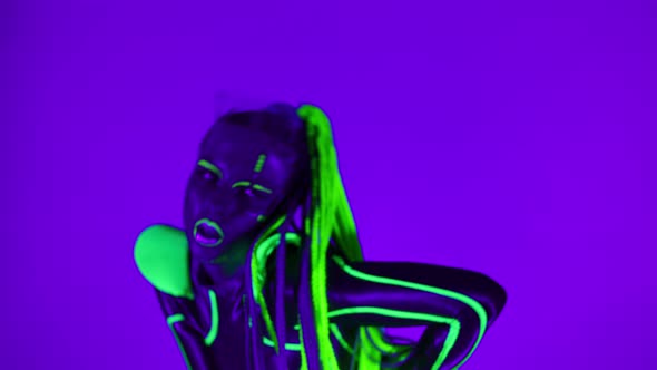 Portrait of Confident Woman with Fluorescent Makeup in Bright Costume Dancing Robotic Dance Looking alt