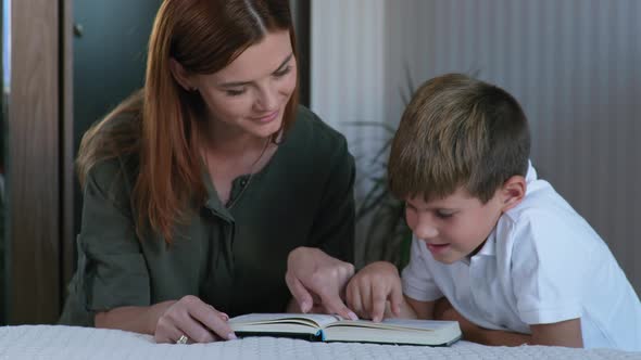 Christian Family, Mom and Son Enjoy Reading the Bible at Bedtime in the Room alt