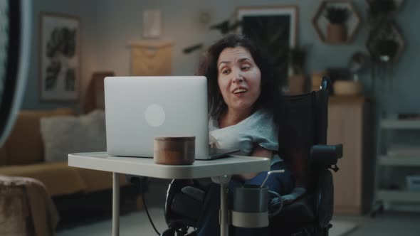 Woman with a Disability Editing Video on Laptop alt