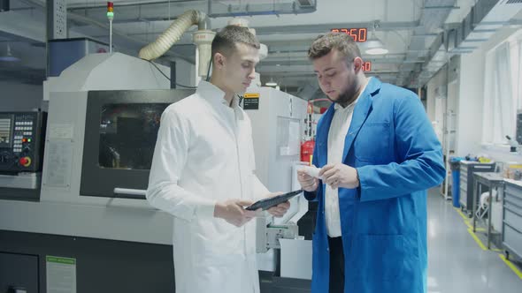 Engineer and Technician Discussing Production Process at Factory