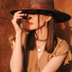 Young fashion girl dressed in a summer dress with a wicker wide hat walks  and poses in the old city Stock Photo by diignat