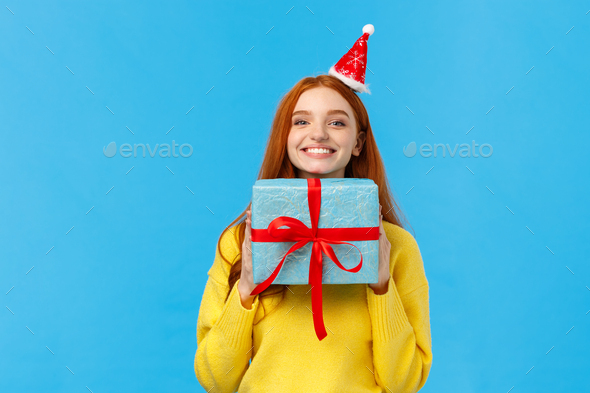 Excited and happy cute redhead girlfriend enjoy celebrating christmas, secret santa event as receive