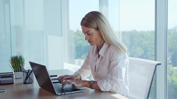 Happy Businesswoman Finish Working on Laptop Put Hands Behind Head in Office alt