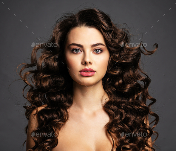 Beautiful young woman with long curly brown hair Stock Photo by valuavitaly