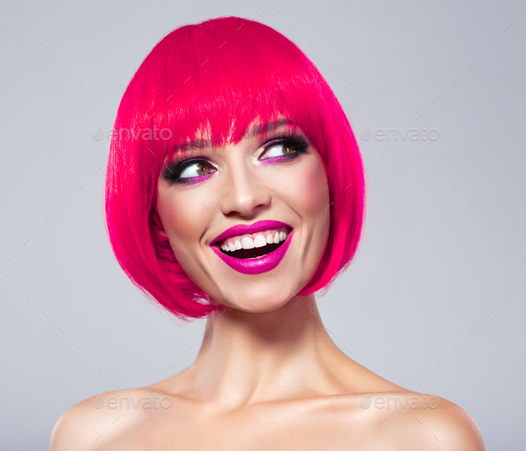 Fun fashion model with bright make-up. Laughing Model with creative colored bob hairstyle.