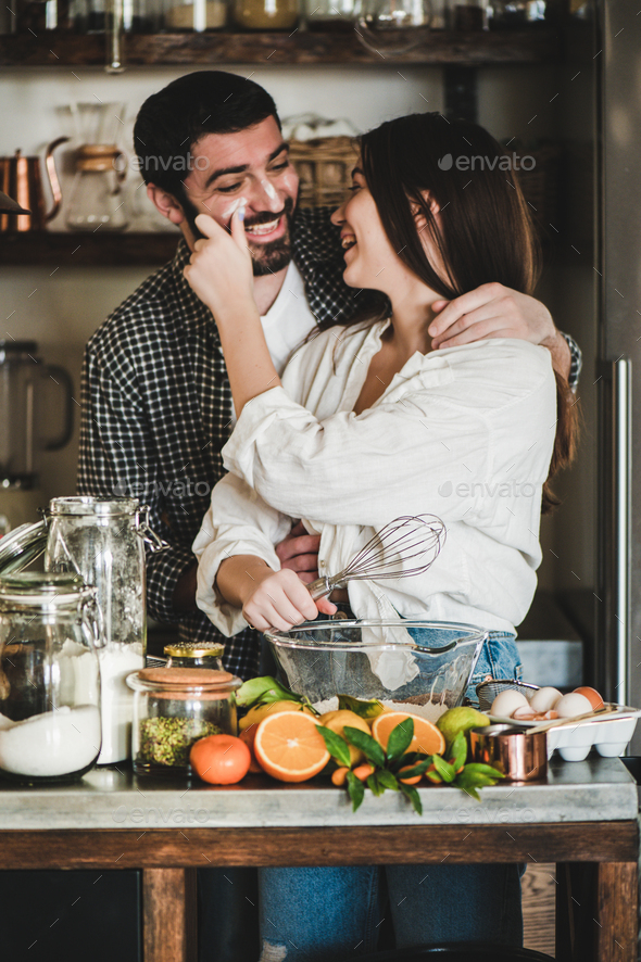 Young happy couple baking pie together for Valentines day - Stock Photo - Images