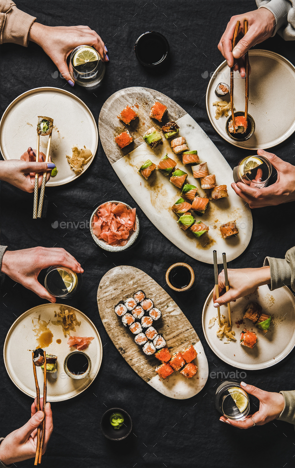 Flat-lay of people eating various sushi during japanese lockdown dinner - Stock Photo - Images