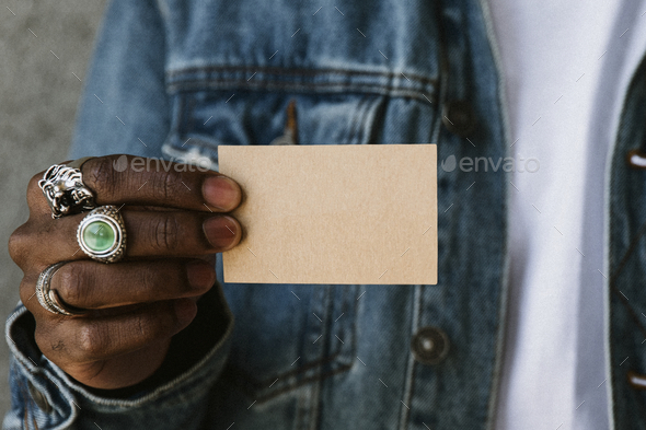 Hand with rings holding a name card