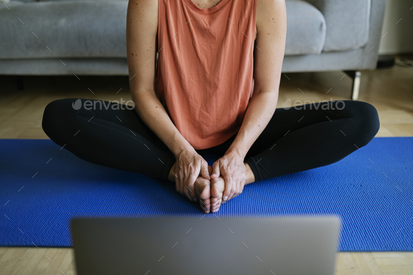 Woman taking an online yoga class during coronavirus quarantine