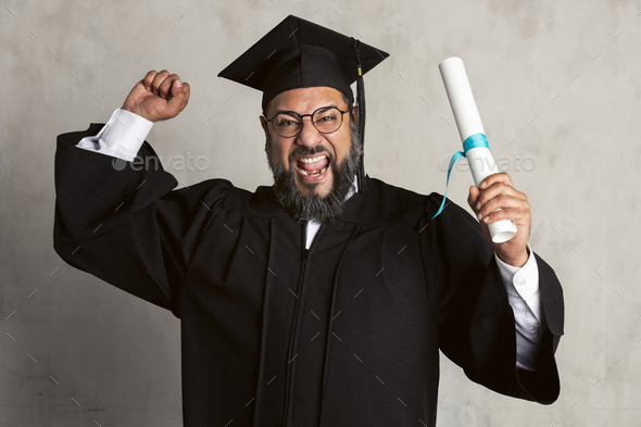 Happy senior man in a graduation gown holding his master's degree