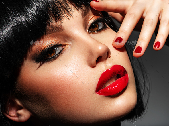 Beautiful brunette girl with red lips. Pretty young sensual woman with red  nails. Stock Photo by valuavitaly