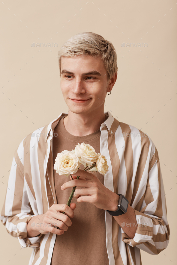 Feminine Young Man Holding Flowers Stock Photo by seventyfourimages