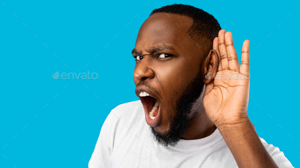 Funny Black Guy Listening Holding Hand Near Ear, Blue Background