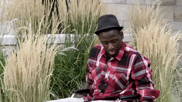 Man in wheelchair answering cell phone. alt