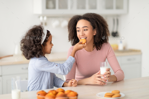 Joyful little african american girl making cookies for her family Stock  Photo by Prostock-studio