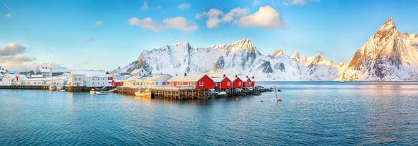 Traditional Norwegian red wooden houses (rorbuer) on the shore of Reinefjorden near Hamnoy village. - Stock Photo - Images