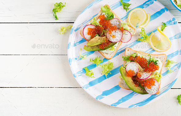 Sandwiches with salmon red caviar with sliced avocado and radish. - Stock Photo - Images