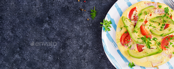 Omelette with ham, tomatoes and avocado on grey table. - Stock Photo - Images