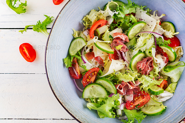 Ketogenic salad with prosciutto, tomatoes, cucumber, lettuce, red onion and cheese - Stock Photo - Images
