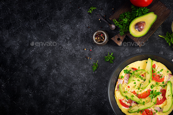 Omelette with ham, tomatoes and avocado on grey table - Stock Photo - Images