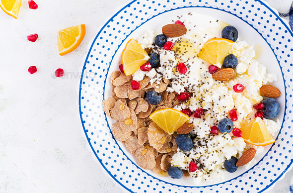 Bowl of flakes with cottage cheese and yogurt, blueberryes and pomegranate - Stock Photo - Images