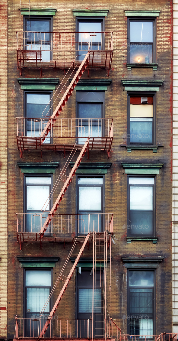 Old townhouse building with iron fire escape in New York City.