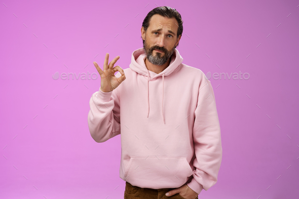 Not bad may better. Portrait handsome mature bearded father wearing trendy hoodie frowning awkward