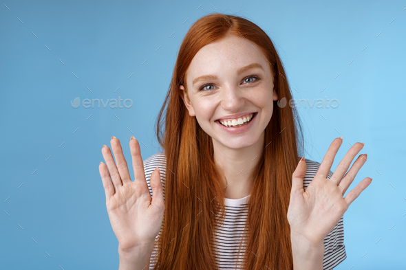 Charming redhead elder sister say goodbye sibling friends smiling cheerful waving raised palms show